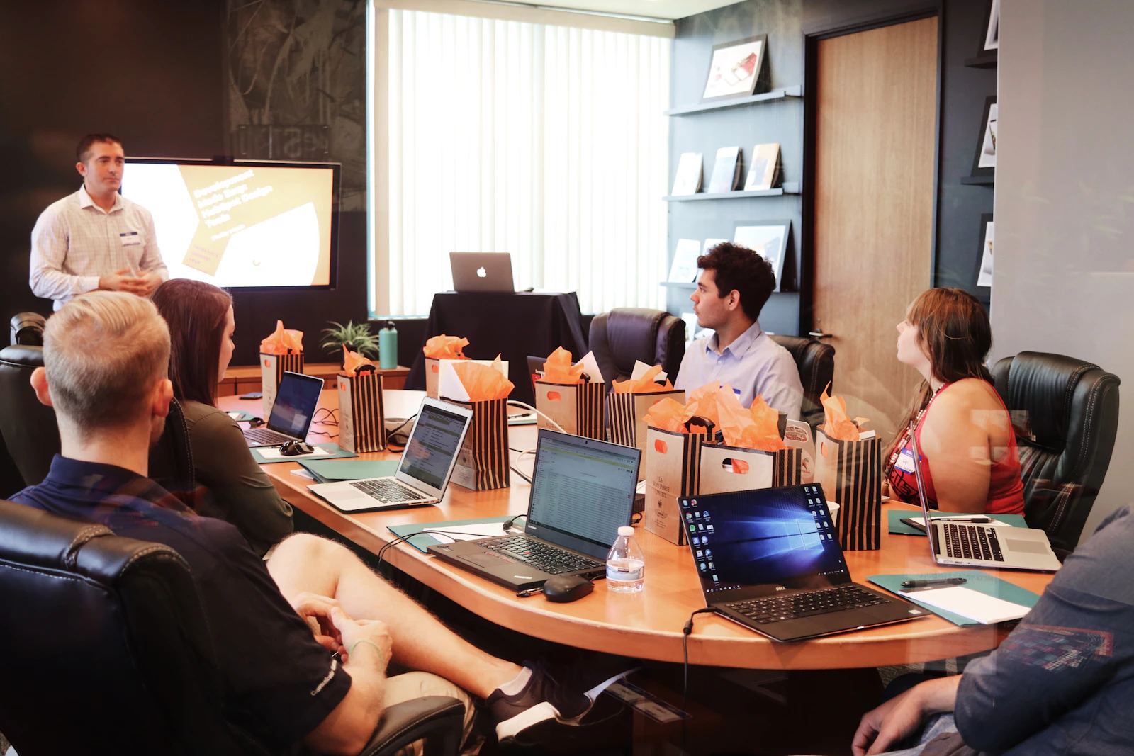 A developer reviewing code on a large monitor in a dimly lit workspace